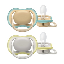 Load image into Gallery viewer, Two Philips Avent ultra air pacifiers in beige and gray colors with blue and yellow trim, designed for 0-6 month old babies.