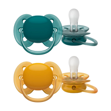 Load image into Gallery viewer, Two baby pacifiers with flexible shields in teal and orange colors, designed for comfort and soothing.