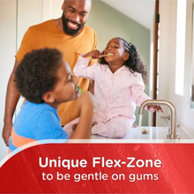 Load image into Gallery viewer, A smiling father watches his son and daughter brush their teeth together in a bright bathroom, with a red banner at the bottom stating "Unique Flex-Zone to be gentle on gums".