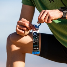 Load image into Gallery viewer, A close-up of an athlete in green sportswear opening a Vitaldin Sport Hydro Energy Gel in Cola flavour. The image highlights the "easy open" stick pack design intended for use during physical activity.