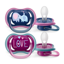 Load image into Gallery viewer, Toddler girl reading a book while using Philips Avent Ultra Air pacifier with 'Love' design