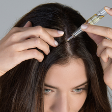 Load image into Gallery viewer, Woman applying Crescina HFSC Transdermic hair treatment along her hair parting using an ampoule applicator for targeted thinning hair care.