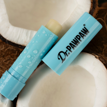 Load image into Gallery viewer, Dr. PAWPAW Coconut Lip Balm Stick in blue packaging displayed alongside fresh coconut halves, highlighting its tropical coconut scent.