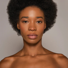 Load image into Gallery viewer, Dr.PAWPAW Shimmer Balm applied on a dark skin model showing a subtle shimmer glow.
