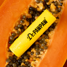 Load image into Gallery viewer, Dr.PAWPAW balm stick placed on open papaya
