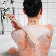 Load image into Gallery viewer, Person using the long-handled EcoTools bristle bath brush with soapy lather to wash their back in the bathtub.