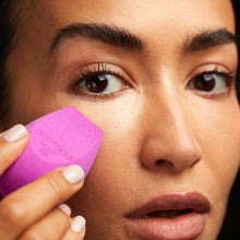 Load image into Gallery viewer, Woman applying liquid concealer under her eye using the purple EcoTools BioBlender compostable makeup sponge.