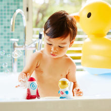 Load image into Gallery viewer, Child playing with Galaxy Buddies light-up bath toys set in the bathtub, showing the astronaut and rocket ship together.
