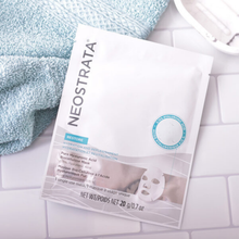 Load image into Gallery viewer, A single-use sachet of NeoStrata Restore Pure Hyaluronic Acid Biocellulose Mask resting on a white tiled surface next to a light blue textured towel. The packaging highlights 0.15% Hyaluronic Acid for hydration and replenishment.