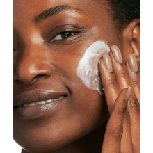 Load image into Gallery viewer, A close-up lifestyle image of a smiling person applying the white NeoStrata Glycolic Renewal Smoothing Cream to their cheek with their fingertips.