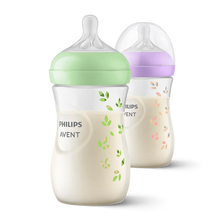 Load image into Gallery viewer, Two Philips Avent Natural Response 260ml baby bottles, one in purple and one in teal green. Both feature clear nipples and caps with the Philips Avent logo on the side.