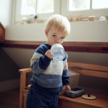 Load image into Gallery viewer, Toddler holding and drinking from Philips Avent Natural Response Trainer Cup in a cozy room.