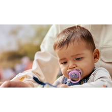 Load image into Gallery viewer, A toddler wearing denim overalls and using a pink tiger-themed Philips Avent Ultra Air soother (SCF087/13) in an outdoor setting.