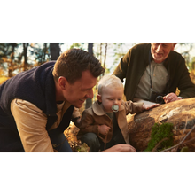 Load image into Gallery viewer, A young child in a tan jacket using a light green wave-patterned Philips Avent Ultra Air soother (SCF349/51) while exploring an autumn forest with family.
