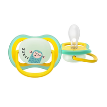 Load image into Gallery viewer, A close-up of a yellow and teal Philips Avent Ultra Air Nighttime soother (SCF376/32) for 18m+ featuring a glow-in-the-dark monkey design and extra-firm teat.