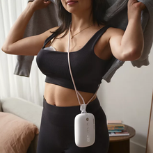 Load image into Gallery viewer, Woman wearing sports apparel with a Philips Avent breast pump collection cup in her bra and motor unit around her neck via lanyard.