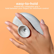 Load image into Gallery viewer, Real Techniques palette with collapsible grip held between fingers for controlled brush cleaning.