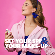 Load image into Gallery viewer, A woman smiling and using Clear Sun Spray SPF 50 as a makeup setting spray.