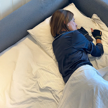 Load image into Gallery viewer, Lifestyle view of the Uriel Carpal Tunnel Night Mitten being worn during sleep, showing the ergonomic design and comfortable padding that provides nighttime wrist relief.