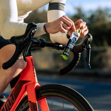 Load image into Gallery viewer, Cyclist opening Vitaldin Hydro Energy Gel during training, ideal for hydration and energy on the go.