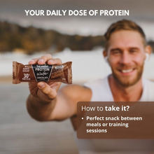 Load image into Gallery viewer, A man holding a Vitaldin chocolate protein wafer bar outdoors with text overlaying the image stating "Your Daily Dose of Protein" and describing it as a perfect snack for between meals or training sessions.