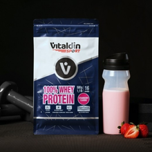 Load image into Gallery viewer, A bag of Vitaldin Sport strawberry whey protein next to a prepared pink protein shake and fresh strawberries in a gym setting.