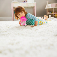Load image into Gallery viewer, A toddler lying on a fluffy white carpet, drinking from a pink weighted straw trainer cup. The cup has handles for easy grip and a flip-top lid to cover the straw.