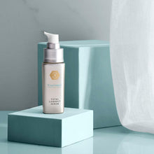 Load image into Gallery viewer, Exuviance Professional Total Correct Serum elegantly displayed in a silver pump bottle on geometric blocks, highlighting its premium, professional-grade formulation for comprehensive skin correction.