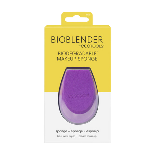 A purple biodegradable makeup sponge from Eco Tools, placed in front of its yellow packaging box with 'BIOBLENDER' and '100% biodegradable makeup sponge' printed on it.
