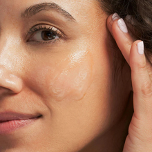 Load image into Gallery viewer, Close-up of a woman&#39;s face with the exfoliating mask and a hand near her ear
