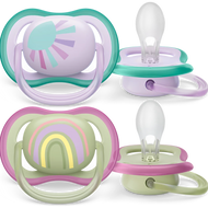 Two Philips Avent ultra air pacifiers designed for 0-6 month old babies, with extra-large airholes. One pacifier has a green handle with a sun design, and the other has a purple handle with a rainbow design.
