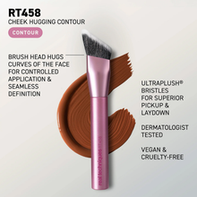 Load image into Gallery viewer, Promotional image of the Real Techniques RT458 Cheek Hugging Contour Brush with a pink metallic handle and angled brush head. The brush is displayed over a brown contour makeup swatch with text highlighting features including face-hugging shape for controlled application, UltraPlush® bristles, dermatologist tested, and vegan and cruelty-free.
