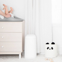 Load image into Gallery viewer, Angelcare Dress Up white nappy bin placed in a modern baby nursery beside a changing table, available with free delivery across Malta &amp; Gozo.
