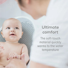 Load image into Gallery viewer, Close-up of a happy baby in the bath support, highlighting the soft-touch material for ultimate comfort that quickly warms to the water temperature.
