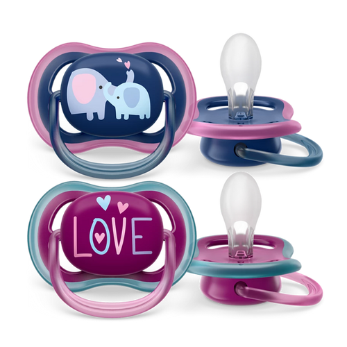Toddler girl reading a book while using Philips Avent Ultra Air pacifier with 'Love' design