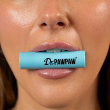 Load image into Gallery viewer, Close-up of a person holding the blue Dr. PAWPAW Coconut Lip Balm Stick between their lips, showcasing the coconut-scented lip care product.

