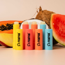 Load image into Gallery viewer, Dr. PAWPAW Original, Coconut, Watermelon and Mango Lip Balm Sticks displayed together alongside fresh papaya, coconut and watermelon, showcasing the four lip balm varieties.

