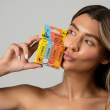 Load image into Gallery viewer, Light-skinned model holding Dr.PAWPAW 4-pack tropical balm set
