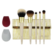 Load image into Gallery viewer, EcoTools Beautifully Bronzed gift set displayed against a black background, featuring five makeup brushes, two beauty sponges, and a gold clutch storage pouch.
