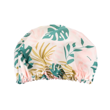 Load image into Gallery viewer, EcoTools reusable shower cap featuring a tropical green and gold leaf pattern isolated on a black background.
