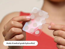 Load image into Gallery viewer, Close-up of acne patches being peeled off the sheet, emphasizing that they are made of medical-grade hydrocolloid for effective pimple extraction and healing.

