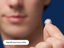 Load image into Gallery viewer, Close-up of a hydrocolloid patch being held, highlighting the instruction to peel off once it turns white, indicating maximum gunk absorption and effective pimple treatment.
