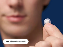 Load image into Gallery viewer, Close-up of a hydrocolloid patch being held, highlighting the instruction to peel off once it turns white, indicating maximum gunk absorption and effective pimple treatment.
