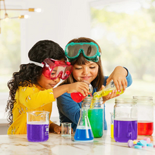 Load image into Gallery viewer, Two children wearing goggles mix colourful liquids in jars during a fun science-style activity.
