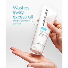 Load image into Gallery viewer, A person’s hands dispensing the clear NeoStrata Mandelic Clarifying Cleanser from a white 200 ml tube onto an open palm. Blue text next to the tube states that the cleanser washes away excess oil and problematic bacteria.
