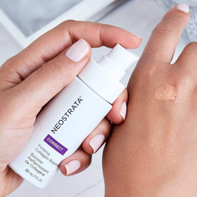 Load image into Gallery viewer, A close-up lifestyle image of hands holding a white 30 mL pump bottle of NeoStrata Correct Firming Collagen Booster serum. One hand holds the bottle while the other has a clear drop of the serum on the back of the hand, demonstrating its texture. The person features a light neutral manicure.
