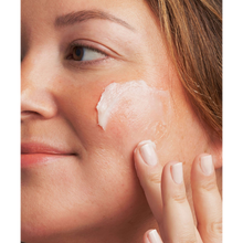Load image into Gallery viewer, A close-up lifestyle image of a person with fair skin applying the white NeoStrata Bionic Face Cream to their cheek with their fingertips.
