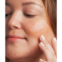 Load image into Gallery viewer, A close-up lifestyle image of a person applying the clear NeoStrata Bionic Face Serum to their cheek with their fingertips.

