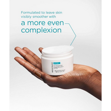 Load image into Gallery viewer, A close-up lifestyle image of a person with deep skin holding an open jar of NeoStrata Restore PHA Renewal Pads in their palm. One of the circular white pads is slightly lifted from the jar, and teal text above states that the formula is designed to leave skin visibly smoother with a more even complexion.
