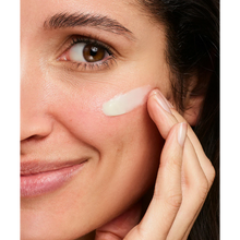 Load image into Gallery viewer, A close-up of a person smiling and applying NeoStrata Restore Redness Neutralizing Serum to their cheek.
